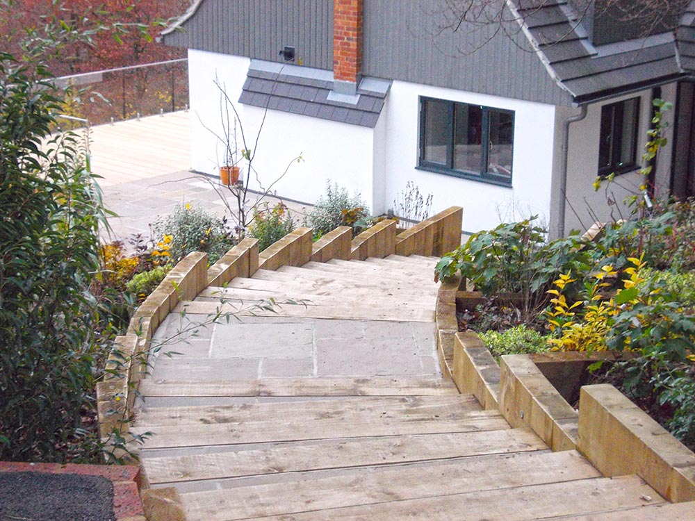 Steps down to hillside house using stone and sleepers