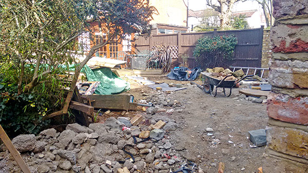 Patio from the side of the house showing debris left by the builder